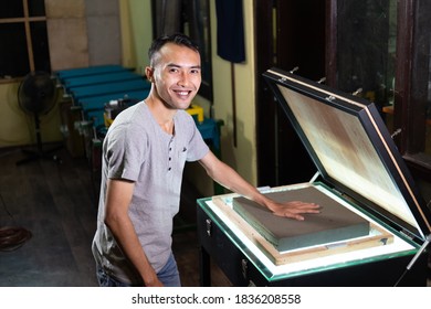 Smiling Man Working To Press A Sponge To Prepare Make Film On Silk Screen Surface