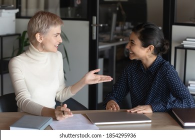 Smiling manager consulting client customer at meeting, discussing contract terms, friendly hr manager holding job interview with candidate, diverse business partners negotiations in office