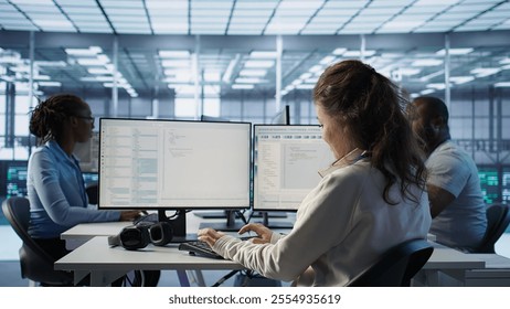 Smiling manager in server hub using computer to find firewall misconfigurations affecting rackmounts performance. Upbeat supervisor checking systems bottlenecks affecting data transfer rates, camera B
