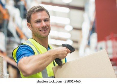 Smiling Manual Worker Scanning Package In Warehouse