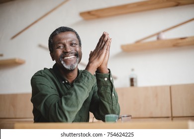 Smiling Mature African American Man Sitting In Cafe