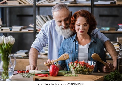 Smiling Mature Couple Cooking Healthy Vegetable Salad Together