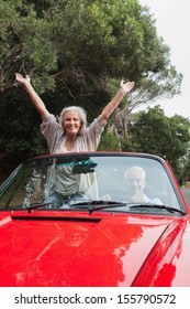 Smiling Mature Couple Having A Ride Together In Red Convertible