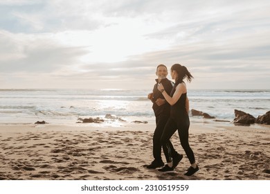 Smiling mature european husband and wife jogging, enjoy workout together in morning on sea beach, outdoor, full length. Sports, fitness and body care, run with coach and active lifestyle - Shutterstock ID 2310519559