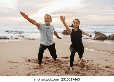 Smiling mature european woman and man in sportswear practice yoga, meditate, enjoy workout together on sea beach, outdoor. Sports in morning, fitness and body care, active lifestyle - Powered by Shutterstock