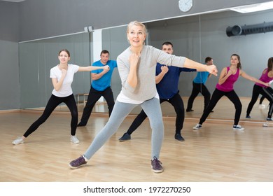 Smiling Mature Female Doing Dance Workout During Group Classe In Fitness Center