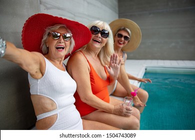 Smiling Mature Ladies Having Fun Around The Swimming Pool Stock Photo