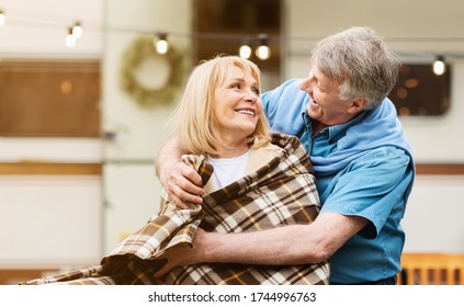 Smiling Mature Man Covering His Wife With Warm Blanket Near RV At Camping Site. Panorama