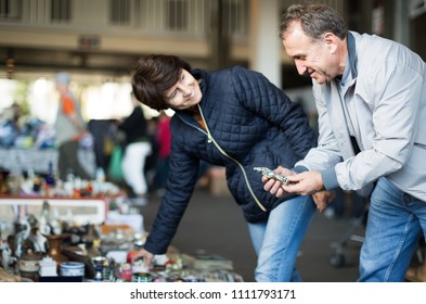 Smiling Mature Spouses Buying Retro Handicrafts On Indoor Flea Market