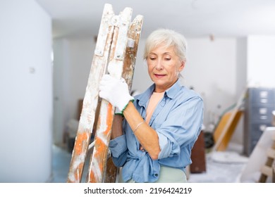 Smiling Mature Woman Carrying Ladder, Working On Home Renovation With Her Own Hands