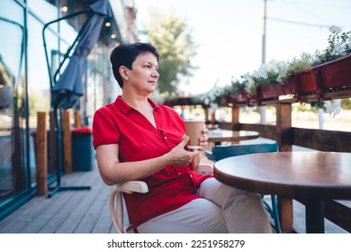 Smiling mature woman drinking coffee outdoors - Shutterstock ID 2251958279