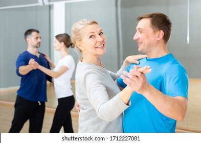 Smiling Mature Woman Enjoying Slow Foxtrot In Dance Studio For Adults

