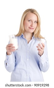 Smiling mature woman with lactose intolerance holding a glass of milk and a pill box containing a lactase enzymatic supplement to aid digestion of dairy products