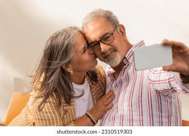 Smiling mature woman and man in casual make selfie on smartphone, enjoy date together in cafe table, outdoor. Love, relationship, free time and weekend, pension, app for photo and video call - Shutterstock ID 2310519303
