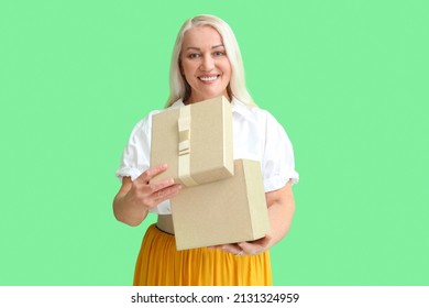 Smiling Mature Woman Opening Gift Box On Green Background. International Women's Day Celebration