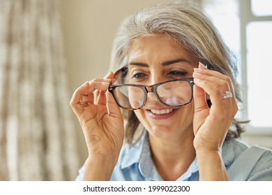 Smiling Mature Woman Trying On New Glasses At Home