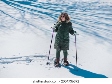 Smiling Mature Woman In Winter Coat Snowshoeing In Fresh Snow  In Midwest; High Angle View