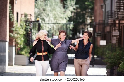 Smiling Mature Women. Happy Group Middle Aged Female Friends Walking Together City Street, Hugging And Laughing. Older Woman Friendship