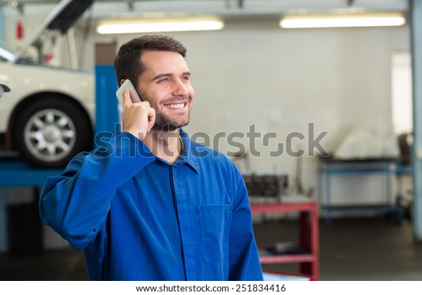 Smiling\
mechanic on the phone at the repair\
garage