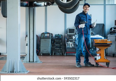 Smiling mechanic at work. Full length portrait