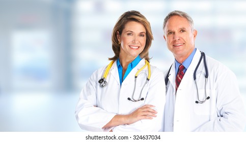 Smiling medical doctors with stethoscope over hospital background
