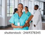 Smiling Medical Professional Holding Clipboard in Multi-Ethnic Hospital Setting