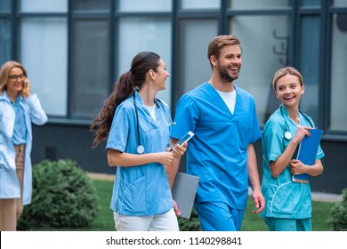 smiling medical students and lecturer walking on street near university - Powered by Shutterstock