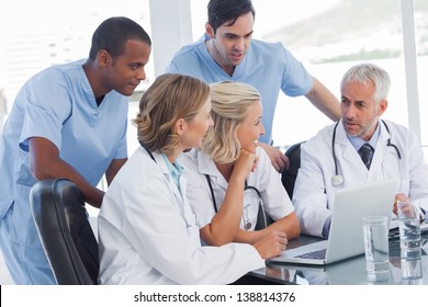 Smiling medical team using laptop to work