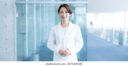 Smiling medical worker wearing a white coat indoors - Powered by Shutterstock