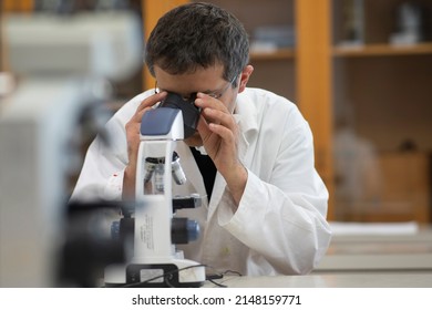 Smiling Microbiologist At Work Into Laboratory Using A Microscope