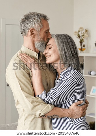 Similar – Image, Stock Photo A middle-aged couple hugging each other and observing a sunset sea, we see them from the back