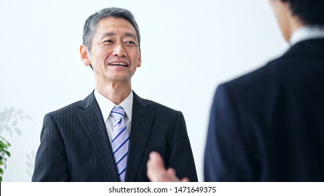 Smiling Middle Aged Asian Businessman. Interview Concept.