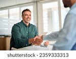 Smiling middle aged business man handshaking partner making partnership collaboration agreement at office meeting, hr manager and new worker shake hands recruiting at job interview. Welcome onboarding