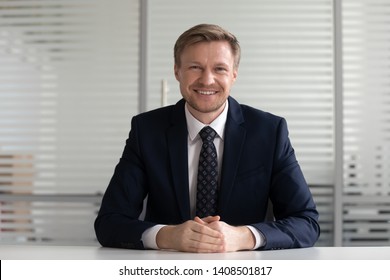 Smiling Middle Aged Businessman Ceo Coach Speaker In Suit Looking At Camera Recording Video Training Advertising Business Services, Happy Professional Sit At Office Desk Posing At Workplace, Portrait