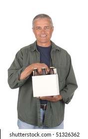 Smiling Middle Aged Man Carrying A Six Pack Of Beer Isolated Over White. Beer Carrier Is Blank And The Brown Bottles Have No Labels. 3/4 View Of The Man In Vertical Format.