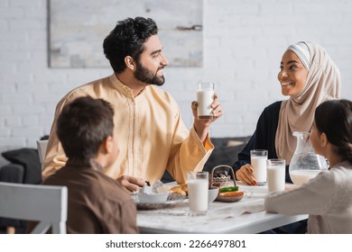 Smiling middle eastern family talking during ramadan breakfast at home - Shutterstock ID 2266497801