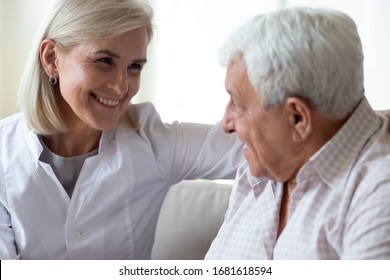Smiling middle-aged female doctor talking with older man close up, discussing good medical checkup result, consulting about prescription, mature woman wearing white uniform supporting elderly patient