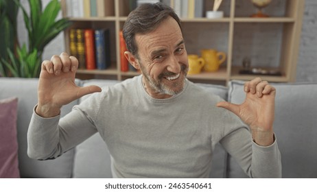 Smiling middle-aged man gesturing tiny size with hands indoors