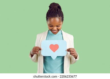 Smiling Millennial African American Girl Isolated On Green Studio Background Show Speech Bubble With Heart. Happy Young Black Woman Demonstrate Love Sign On Paper Share Care. Charity, Volunteer.