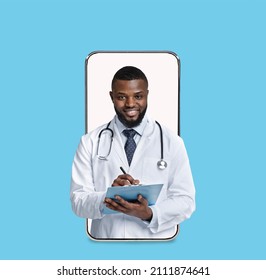 Smiling Millennial African American Male Doctor In White Coat Make Notes On Blank Screen Of Big Phone Isolated On Blue Background, Collage. Medical Service, Health Care, App And Treatment Online