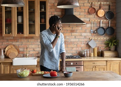 Smiling Millennial Black Male Hipster Taking Break In Cooking Food Process Making Answering Telephone Call. Happy Young Afro American Man Calling Girlfriend By Cell Inviting On Romantic Dinner For Two