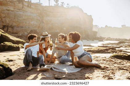 Smiling millennial diverse people student cheers with bottles of beer, enjoy summer holidays, picnic, have fun on beach. Lifestyle, free time, weekend party together outdoor - Powered by Shutterstock