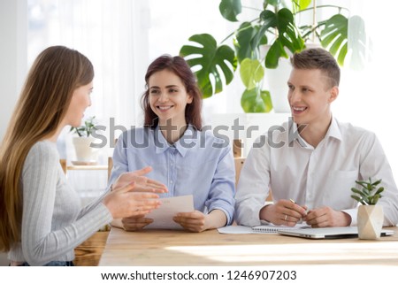 Smiling millennial HR managers listen to female job applicant talking at interview, confident woman speak at hiring process, sharing thoughts or experience, making good first impression on recruiters