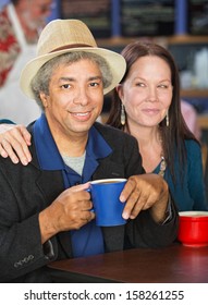 Smiling Mixed Couple Together In Coffee House