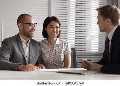 Smiling mixed race family couple meeting real estate agent, bank manager, lawyer, broker, financial advisor at office, listening to good financial offer, savings investment, apartment sale propose. - Powered by Shutterstock