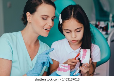 Smiling Mixed Race Girl With Pediatric Dentist Brushing Showing Right Way Brushing Teeth