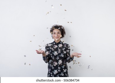 Smiling Mixed Race Woman Throwing Confetti Indoors