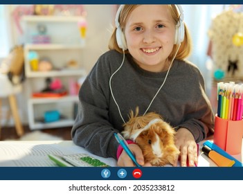 smiling modern child with headphones and guinea pig learning online, having video conference at home in sunny day.