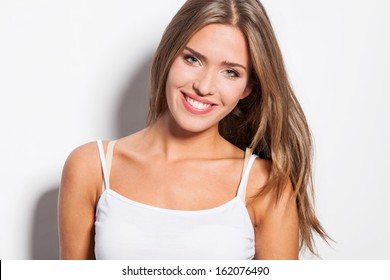 smiling modern natural beauty blonde straight hair girl in white top tank studio shot white background
