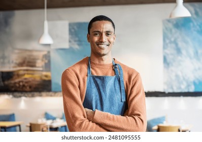 Smiling moroccan young man wearing a casual apron in a modern café. He stands confidently with arms crossed. The background shows a cozy and stylish café setting. - Powered by Shutterstock